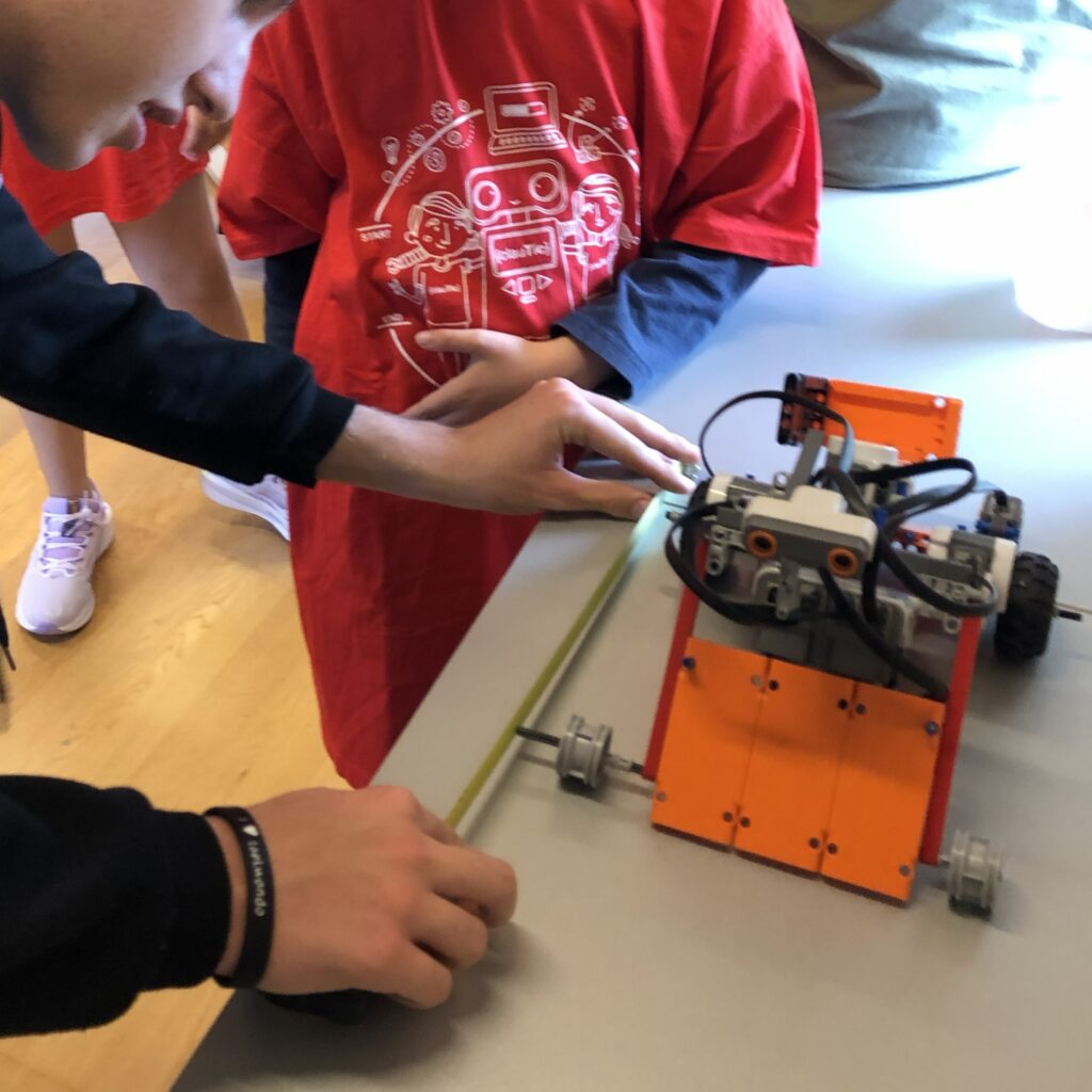 Alumnos de clautico ajustando un robot Lego Mindstorms NXT antes de un combate de sumo de robots